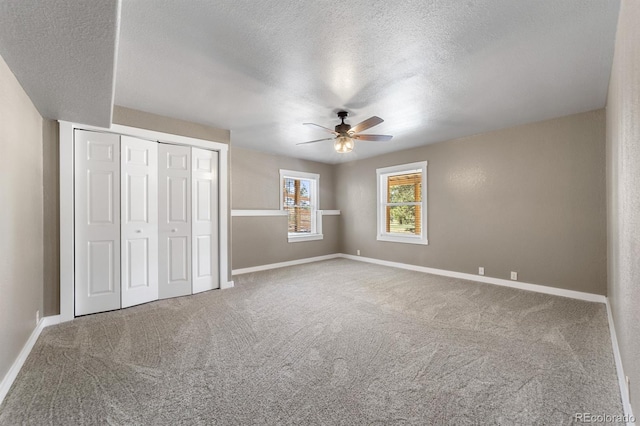 unfurnished bedroom with a textured ceiling, ceiling fan, and carpet flooring