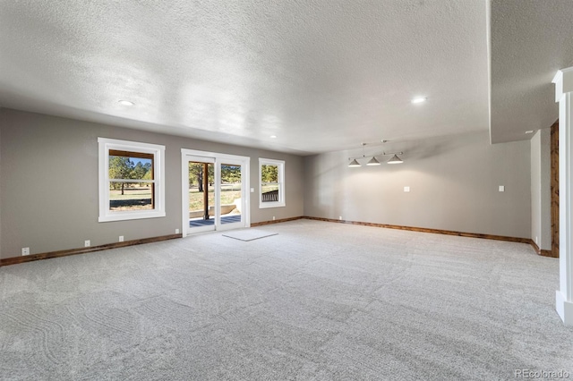 spare room with light carpet and a textured ceiling