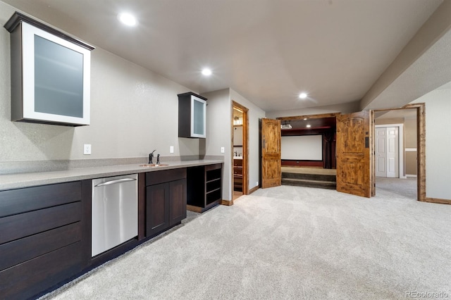 kitchen featuring light carpet, dark brown cabinetry, and stainless steel dishwasher