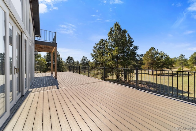 wooden deck featuring a lawn