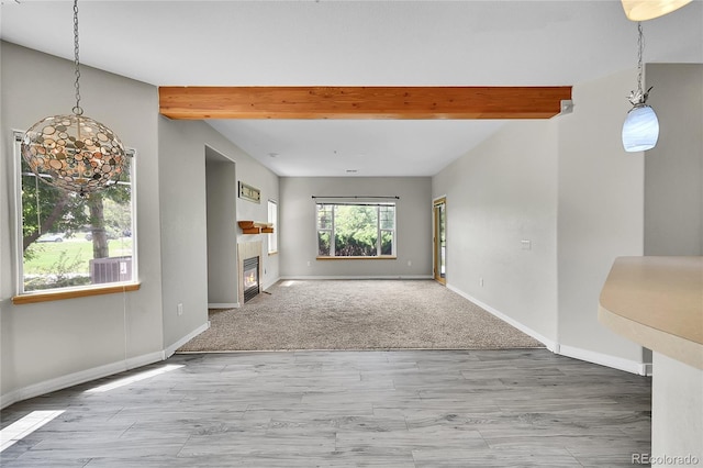 5220 Boardwalk Dr Unit A14, Fort Collins, CO 80525 - unfurnished living room featuring beam ceiling, a glass covered fireplace, and wood finished floors