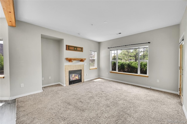 5220 Boardwalk Dr Unit A14, Fort Collins, CO 80525 - unfurnished living room with a tile fireplace, carpet, and beam ceiling