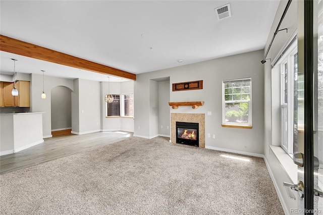5220 Boardwalk Dr Unit A14, Fort Collins, CO 80525 - unfurnished living room featuring light carpet, beam ceiling, arched walkways, and a fireplace