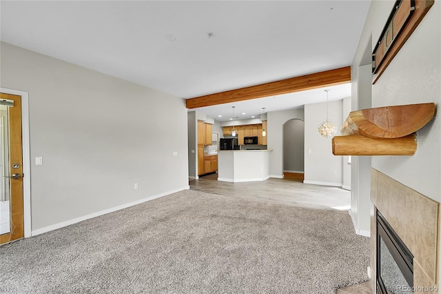 5220 Boardwalk Dr Unit A14, Fort Collins, CO 80525 - unfurnished living room featuring light colored carpet, arched walkways, beam ceiling, a fireplace, and recessed lighting