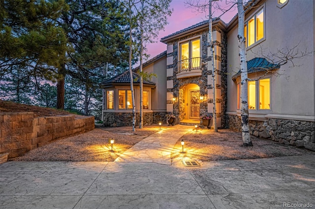 22554 Treetop Ln, Golden, CO 80401 - view of front of home featuring a balcony, stone siding, a tile roof, and stucco siding