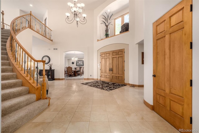 22554 Treetop Ln, Golden, CO 80401 - entrance foyer featuring a chandelier, arched walkways, stairway, baseboards, and light tile patterned floors