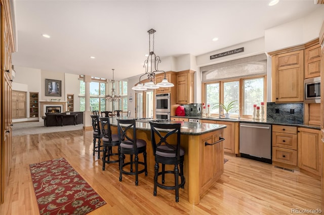22554 Treetop Ln, Golden, CO 80401 - kitchen featuring appliances with stainless steel finishes, backsplash, a kitchen bar, a kitchen island, and recessed lighting