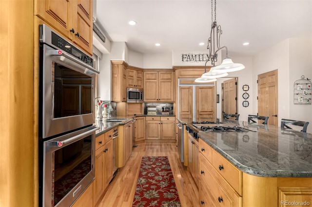 22554 Treetop Ln, Golden, CO 80401 - kitchen with appliances with stainless steel finishes, a sink, a large island, light wood-style floors, and recessed lighting