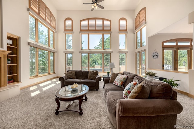 22554 Treetop Ln, Golden, CO 80401 - carpeted living room featuring a towering ceiling, plenty of natural light, ceiling fan, and baseboards