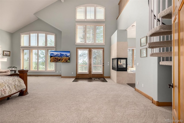 22554 Treetop Ln, Golden, CO 80401 - carpeted bedroom with high vaulted ceiling, multiple windows, a tiled fireplace, and baseboards
