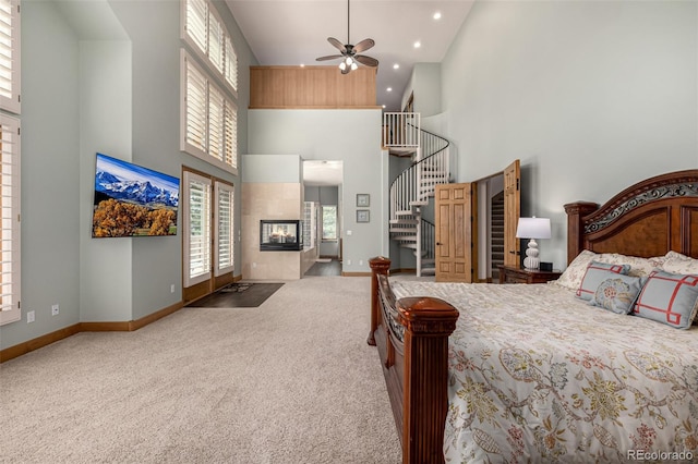 22554 Treetop Ln, Golden, CO 80401 - carpeted bedroom with high vaulted ceiling, a tiled fireplace, baseboards, and recessed lighting
