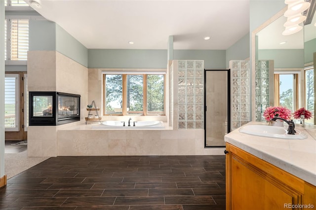 22554 Treetop Ln, Golden, CO 80401 - bathroom featuring a garden tub, a stall shower, vanity, and wood finished floors