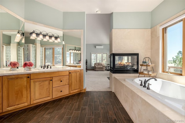 22554 Treetop Ln, Golden, CO 80401 - full bathroom with vanity, a whirlpool tub, wood finished floors, and a tiled fireplace