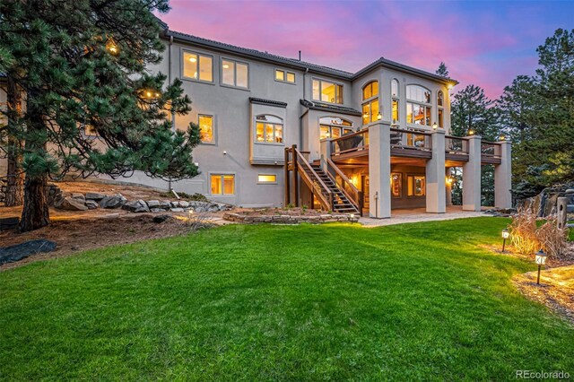 22554 Treetop Ln, Golden, CO 80401 - rear view of property featuring stairway, a deck, a yard, and stucco siding