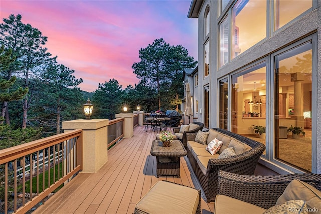 22554 Treetop Ln, Golden, CO 80401 - deck at dusk with outdoor dining area and an outdoor hangout area