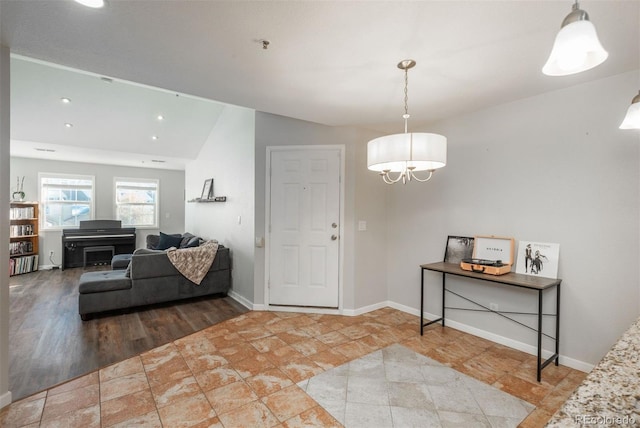 foyer entrance with hardwood / wood-style floors, lofted ceiling, a notable chandelier, and radiator