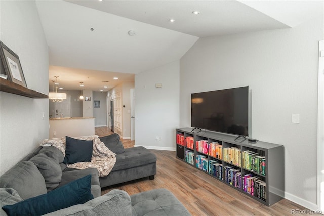 living room featuring lofted ceiling and hardwood / wood-style flooring