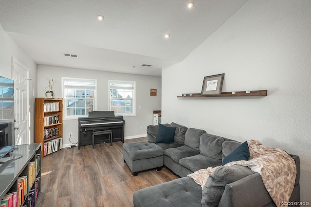 living room featuring lofted ceiling and dark hardwood / wood-style floors