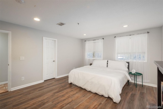 bedroom with dark hardwood / wood-style floors