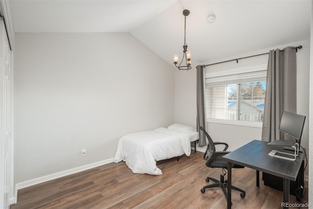 bedroom with hardwood / wood-style floors, vaulted ceiling, and a notable chandelier