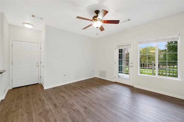 spare room with visible vents, a ceiling fan, and wood finished floors