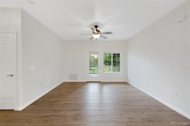 unfurnished room featuring visible vents, wood finished floors, baseboards, and ceiling fan