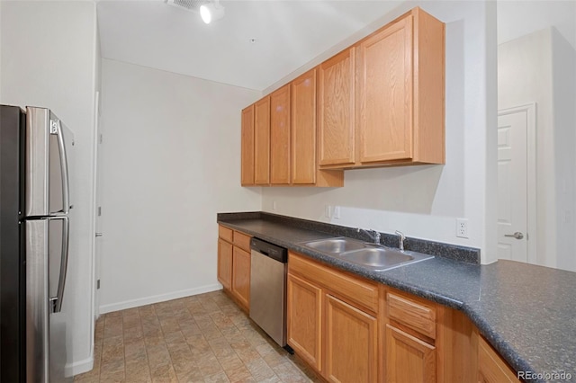 kitchen featuring a sink, baseboards, dark countertops, and appliances with stainless steel finishes