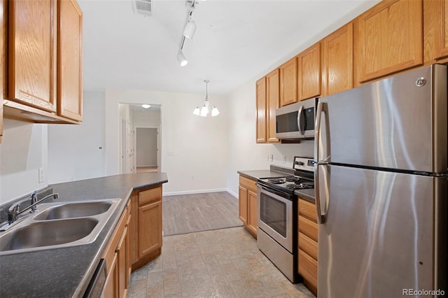 kitchen featuring dark countertops, visible vents, baseboards, stainless steel appliances, and a sink