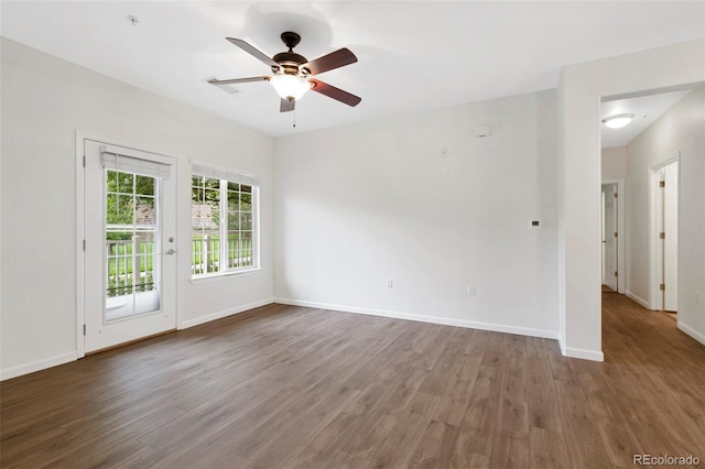 empty room with baseboards, wood finished floors, and a ceiling fan