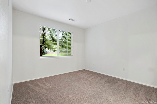 unfurnished room with visible vents, baseboards, and carpet flooring