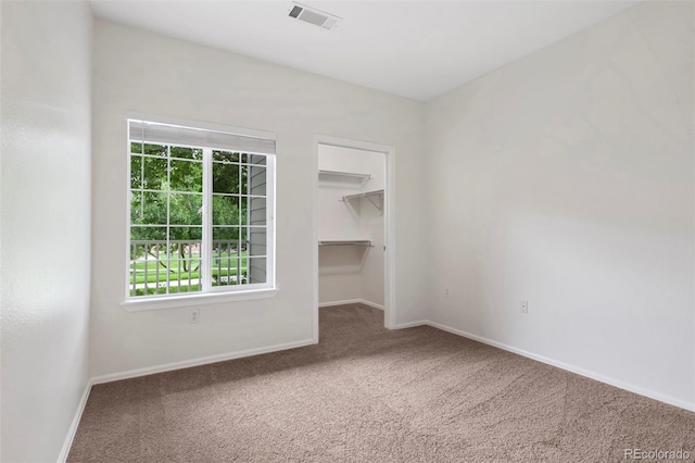 carpeted spare room with visible vents and baseboards