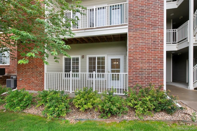 entrance to property with brick siding and central air condition unit