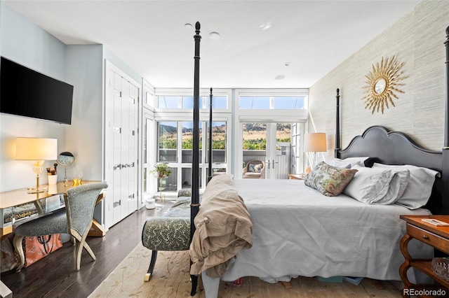 bedroom with french doors, a wall of windows, dark hardwood / wood-style flooring, and access to outside