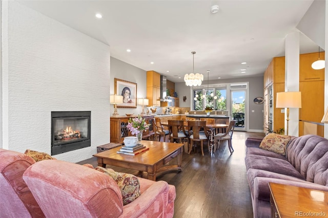 living room featuring an inviting chandelier and dark hardwood / wood-style flooring