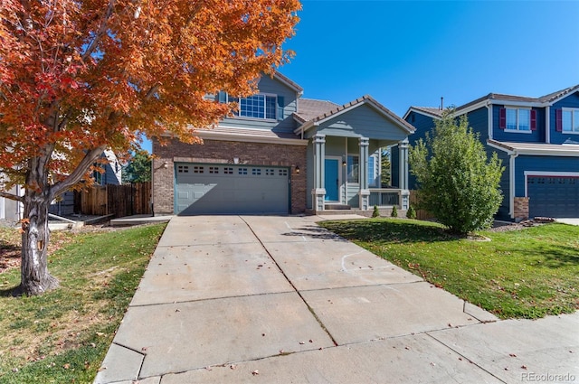 view of front of home featuring a front yard, covered porch, and a garage