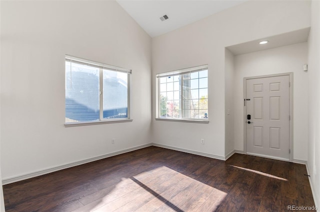 foyer with vaulted ceiling and dark hardwood / wood-style flooring