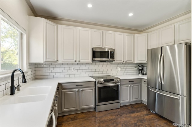 kitchen featuring stainless steel appliances, dark wood-type flooring, sink, and gray cabinetry