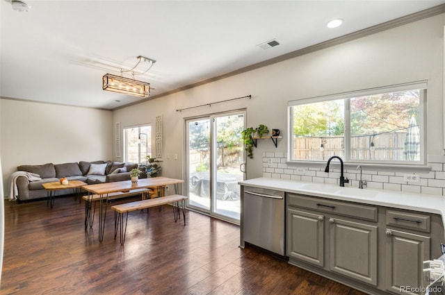 kitchen featuring gray cabinetry, sink, dishwasher, dark wood-type flooring, and decorative backsplash