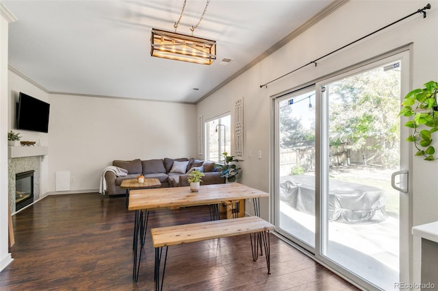 dining area featuring dark wood-type flooring and crown molding