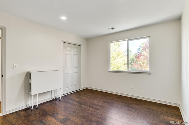 unfurnished bedroom with a closet and dark wood-type flooring