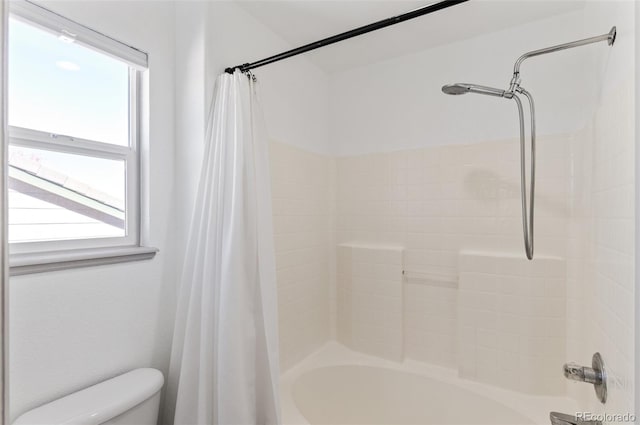 bathroom featuring shower / bath combination with curtain, toilet, and a healthy amount of sunlight