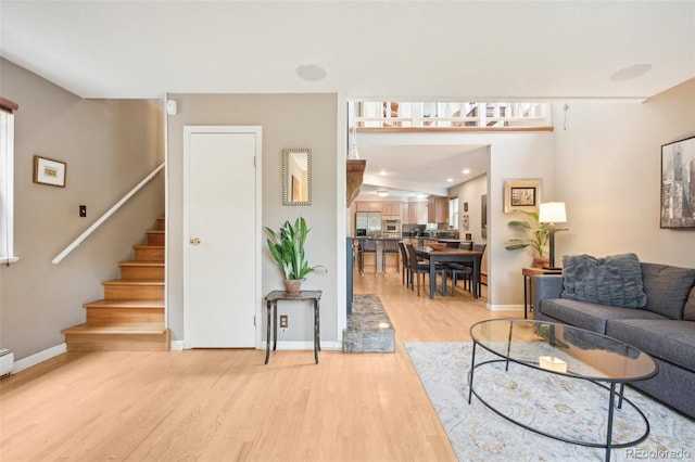 living room featuring light wood-type flooring and vaulted ceiling