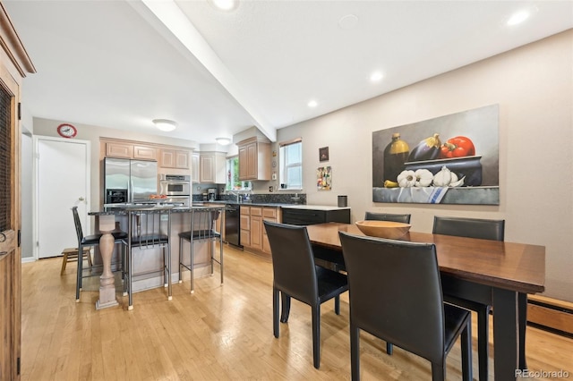 dining space with beamed ceiling and light hardwood / wood-style flooring