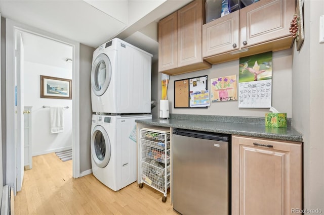 washroom with a baseboard radiator, light hardwood / wood-style flooring, and stacked washer and clothes dryer