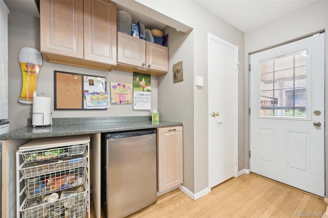 bar featuring fridge and light hardwood / wood-style floors