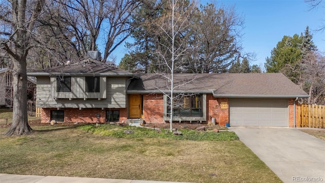 tri-level home with brick siding, fence, a front yard, driveway, and an attached garage