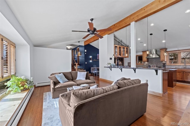 living room featuring a baseboard heating unit, lofted ceiling with beams, light wood-style flooring, and a baseboard radiator