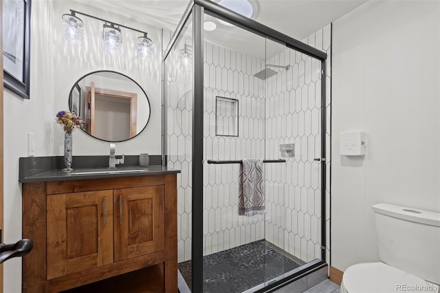 bathroom featuring a stall shower, toilet, and vanity