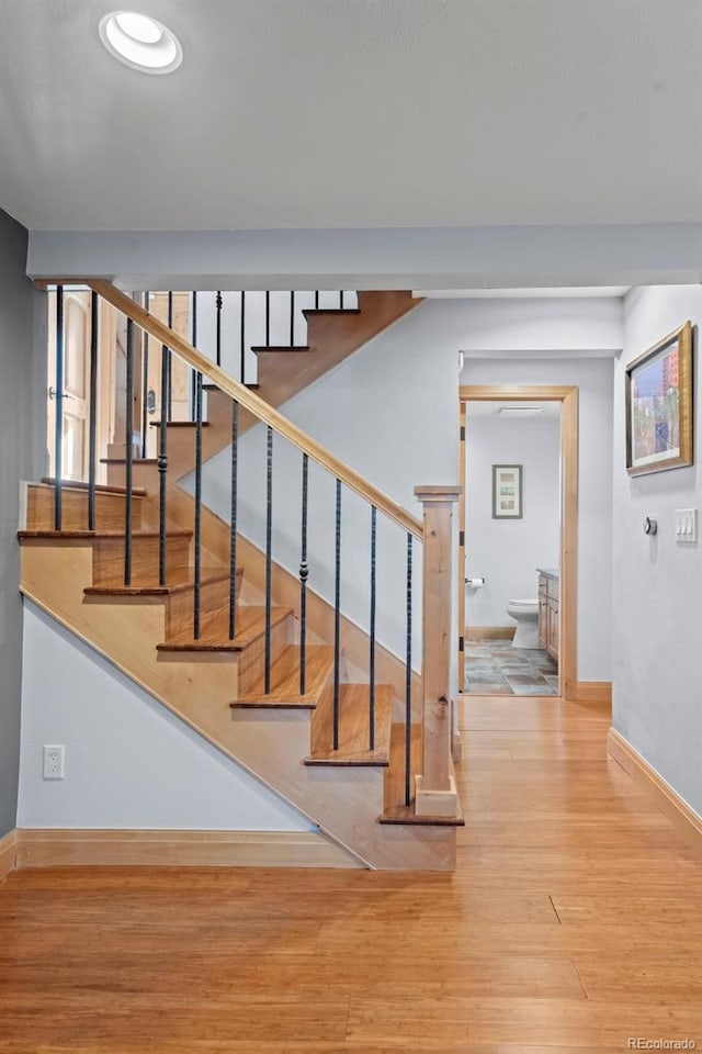 stairs with baseboards and wood finished floors