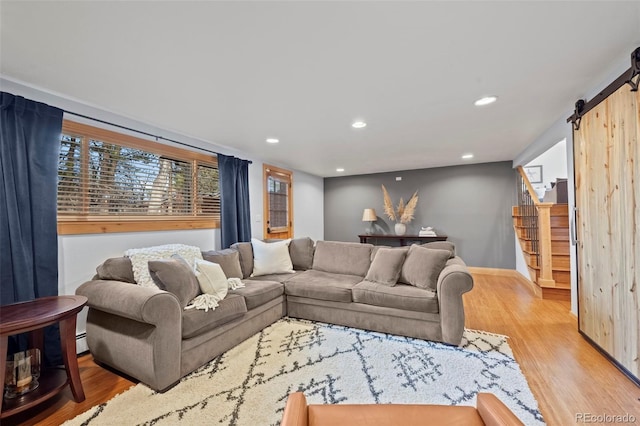 living room with wood finished floors, recessed lighting, a barn door, stairway, and baseboards